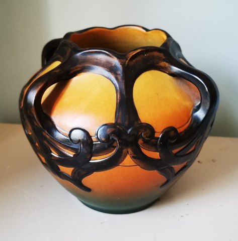 PURE ART NOUVEAU: Pottery jar from the copenhagen pottery factory Peter Ipsen. 
Designed by Karen Hagen in 1909. Orange with black ornamentation in relief and 
decorative handles. Appears in absolutely perfect condition. The factory mark on 
the bottom with, among other things, model number 710. Dimensions: H. 16½ cm.