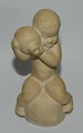 Figure in pottery: boy holding jar by Knud Basse