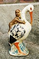 Figur af stork som sparebøsse med baby på ryggen